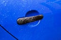 Blue car door handle with rain drops Royalty Free Stock Photo