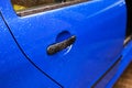 Blue car door handle with rain drops Royalty Free Stock Photo