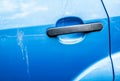 Blue car door handle and scratched car paint with birds droppings Royalty Free Stock Photo