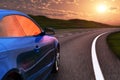 Blue car driving by autobahn in sunset Royalty Free Stock Photo