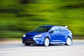 Blue car driving fast on country road Royalty Free Stock Photo