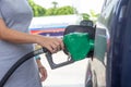 Blue car at gas station filled with fuel. Closeup pregnant woman hand pumping gasoline fuel in car at gas station Royalty Free Stock Photo