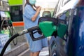 Blue car at gas station filled with fuel. Closeup woman hand pumping gasoline fuel in car at gas station Royalty Free Stock Photo