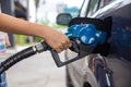 Blue car at gas station filled with fuel. Closeup woman hand pumping gasoline fuel in car at gas station Royalty Free Stock Photo