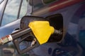 Blue car at gas station filled with fuel. Closeup yelllow pumping gasoline fuel in car at gas station Royalty Free Stock Photo