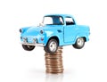 Blue car model jacked by a stack of dollar coins on white background