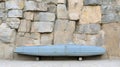A blue car is parked in front of a stone wall Royalty Free Stock Photo