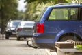 Blue car parked on sunny street, red stop lights, hook for dragging trailer, tow hitch or towbar. Royalty Free Stock Photo