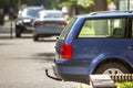 Blue car parked on sunny street, red stop lights, hook for dragging trailer, tow hitch or towbar. Royalty Free Stock Photo