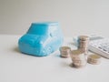 Blue car Piggy bank and calculator with coins pile, Saving money for future plan and retirement fund concept