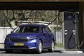 Blue car at a public charging station