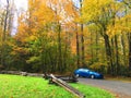 Blue car beside road in Autumn