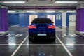 Blue car on the underground parking. Back view, headlights on Royalty Free Stock Photo