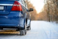 Blue Car with Winter Tires on the Snowy Road. Drive Safe. Royalty Free Stock Photo