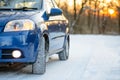 Blue Car with Winter Tires on the Snowy Road. Drive Safe. Royalty Free Stock Photo