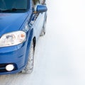 Blue Car with Winter Tires on the Snowy Road. Drive Safe. Space for Text. Royalty Free Stock Photo