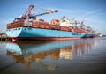 Blue cargo ship mirroring in water at hamburg harbor