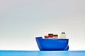 Blue cargo ship toy on an artificial ocean. Royalty Free Stock Photo