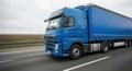 Blue cargo truck driving on highway, showcasing powerful transportation capabilities, with blurred background emphasizing speed Royalty Free Stock Photo