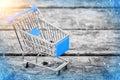 Blue cart from the grocery store on the old wooden background. New Year and Christmas buying. Royalty Free Stock Photo