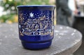 Blue ceramic Christmas mug with an image is on the wooden table