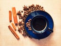 Blue ceramic cup with black coffee drink and coffee beans, cinnamon and star anise spices Royalty Free Stock Photo