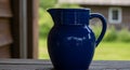 Blue Ceramic Pitcher on Wooden Surface Outdoor Scene Royalty Free Stock Photo