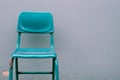 A blue chair sitting against a wall with no legs, AI Royalty Free Stock Photo