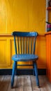 A blue chair sitting in front of a yellow wall, AI