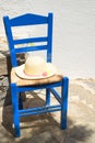 Blue chair with straw hat on it outdoors