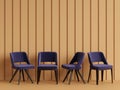 Blue chairs are standing in an empty yellow room with relief stripes on the wall