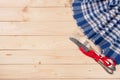 Blue checkered tablecloth with knife and fork on a light wooden table with copy space for your text. Top view Royalty Free Stock Photo