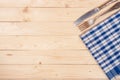 blue checkered tablecloth with knife and fork on a light wooden table with copy space for your text. Top view Royalty Free Stock Photo