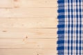 Blue checkered tablecloth on a light wooden table with copy space for your text. Top view Royalty Free Stock Photo