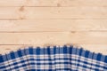 Blue checkered tablecloth on a light wooden table with copy space for your text. Top view Royalty Free Stock Photo