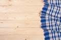 Blue checkered tablecloth on a light wooden table with copy space for your text. Top view Royalty Free Stock Photo