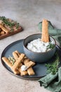 Blue cheese dressing or dip sauce with rosemary and gingerbread cookies sticks on concrete background