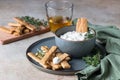 Blue cheese dressing or dip sauce with rosemary and gingerbread cookies sticks on concrete background