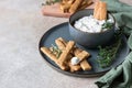 Blue cheese dressing or dip sauce with rosemary and gingerbread cookies sticks on concrete background