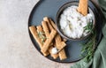 Blue cheese dressing or dip sauce with rosemary and gingerbread cookies sticks on concrete background