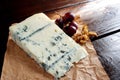 Blue cheese with grapes and walnuts on wooden background