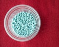 Blue chemical fertilizer in plastic cup