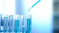 Blue chemical liquid dripping in lab tubes, cleaning agent testing experiment Royalty Free Stock Photo