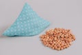 Blue cherry stone pillow, cherry pit filled pillow with cherry stones around on gray background. Natural heat or cool pack.