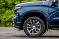 Blue Chevrolet Silverado pickup truck parked in a lush green grassy field.