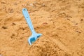 Blue children shovel toy on white sand, plastic play for game. Mound of sand in kindergarden. Royalty Free Stock Photo