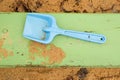 Blue children shovel toy on white sand, plastic play for game. Mound of sand in kindergarden. Royalty Free Stock Photo
