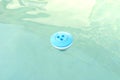 Blue chlorine dispenser floating in a home pool, cleaning and care of the domestic pool. Royalty Free Stock Photo