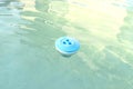 Blue chlorine dispenser floating in a home pool, cleaning and care of the domestic pool. Royalty Free Stock Photo