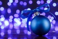 Blue christmas ball and blured purple lights at the background Royalty Free Stock Photo